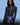 Person wearing a dark gray bodysuit with 'N Dance' logo on a blue background